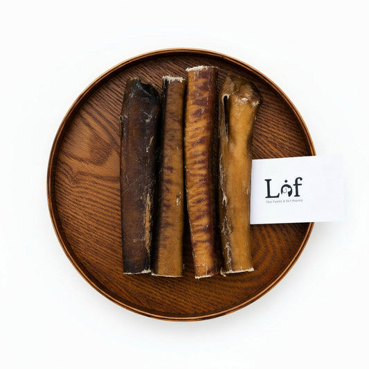 Wooden plate with dog bones and a pen on grass, featuring the brand 'Láf'.